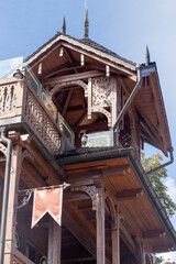 Wooden balcony of a wood house. Exterior facade windows. Old architecture home.