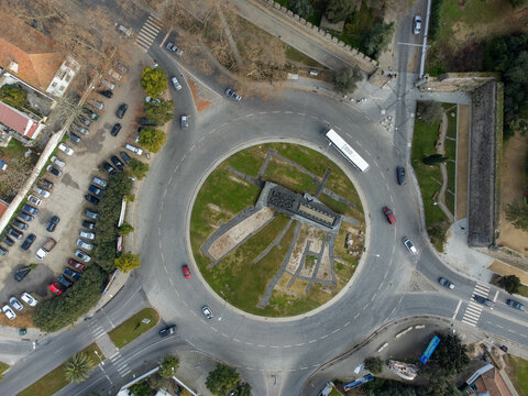Aerial view of the Rotunda das Portas do Raimundo in &Eacute;vora, Portugal. Historic cityscape with iconic roundabout, medieval walls, and surrounding architecture