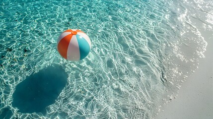 Obraz premium Vibrant multi colored beach ball floating on the crystal clear turquoise waters of a tranquil tropical paradise The calm rippling surface reflects the azure sky creating a serene and peaceful scene