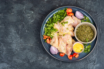 Raw chicken breast fillet with cilantro.