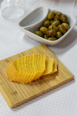 Traditional Portuguese appetizer featuring Alentejo sheep cheese and fresh olives on a restaurant table. Perfect for authentic cuisine and dining themes.