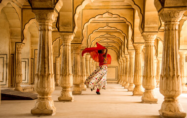 Young female tourist dancing at Pillars room of Amber Fort, Jaipur