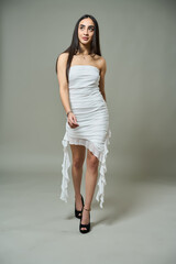 Hispanic woman walking in white dress