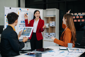 Group of professionals participating in meeting or workshop. presenter standing near flip chart give presentation interact with participants, attendee ask questions, share opinion or solutions.