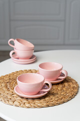 Pink ceramic cup and saucer on light dining table in dining room