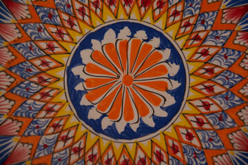 Beautiful round ceramic dish with oriental patterns. Top view. Close-up.