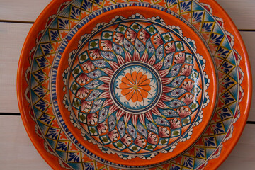 Two beautiful ceramic dishes with oriental patterns lie on a table made of white boards. Top view. Close-up.