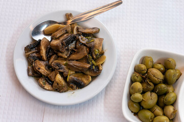 Sauteed mushrooms served as appetizers on a table in a traditional Portuguese restaurant, showcasing authentic local cuisine.
