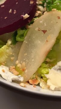 salad with beetroot and greens also cheese nuts in a white plate