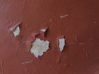 Cracked and peeling paint on the concrete wall