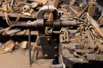 Vintage metal vise in a cluttered workshop