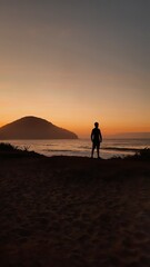 silhueta de homem caminhando na praia no nascer do sol, em ubatuba, são paulo 