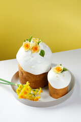 Traditional Ukrainian Paska with Floral Decorations Against a Soft Yellow Background