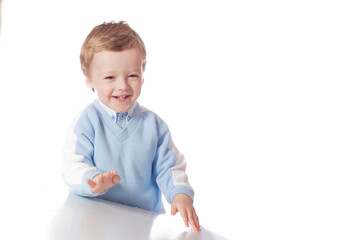 Emotional baby in shirt and blue jumper on white background