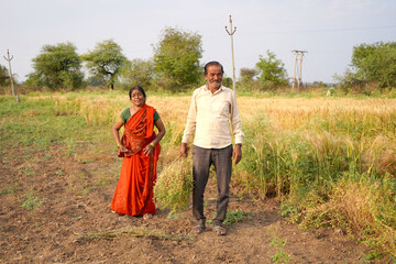 Happy Indian farmer couple in the field.