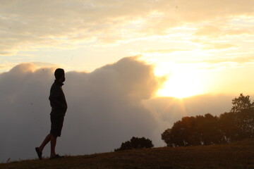 Obraz premium homem no alto de montanha no nascer do sol 