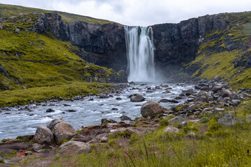 The majestic Gufufoss waterfall cascades into the Fjarðará river near the charming town of Seyðisfjörður in east Iceland