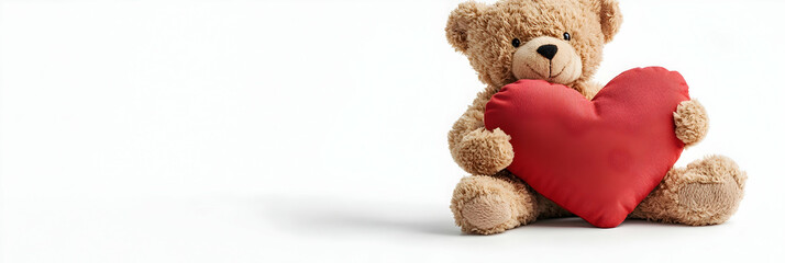 Fototapeta premium A small teddy bear holding a heart-shaped pillow on a clean white background
