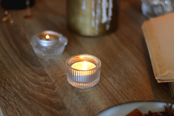Books, lit candles, red wine, snacks and various deocration on the table. Dark academia or Halloween concept. Selective focus.