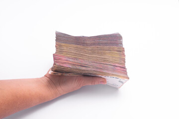 a large stack of paper money in a woman's hand.