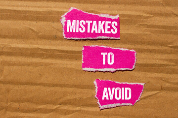Mistakes to avoid message written on ripped torn pink paper pieces on yellow background. Conceptual...