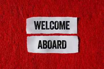 Welcome aboard message written on ripped torn paper pieces on red background. Conceptual welcome...
