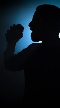 Silhouette of a man opening and drinking from a soda can in slow motion. High quality FullHD footage