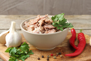 Canned meat in bowl and fresh products on table, closeup