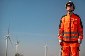 Female Caucasian wind turbine engineer standing with wind power background