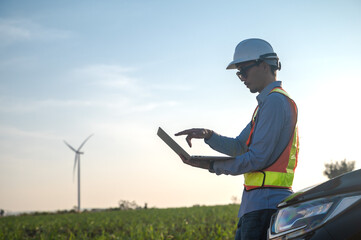 Asian wind turbine engineer man with laptop working in wind power site