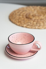Ceramic mug with saucer on kitchen light table