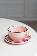 Ceramic mug with saucer on kitchen light table