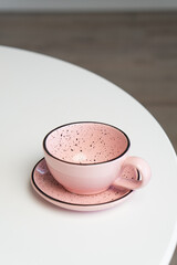 Ceramic mug with saucer on kitchen light table