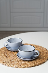 Ceramic mug with saucer on kitchen light table