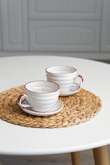 Ceramic mug with saucer on kitchen light table
