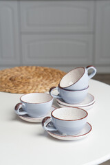 Ceramic mug with saucer on kitchen light table