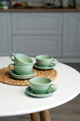 Ceramic mug with saucer on kitchen light table