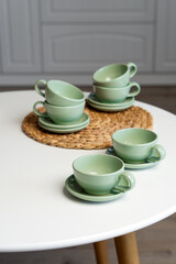 Fototapeta premium Ceramic mug with saucer on kitchen light table