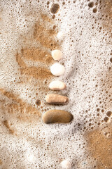 Aesthetic background with sea foam and stones 