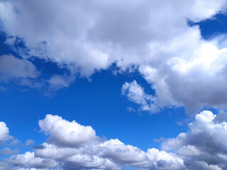 Stunning vibrant blue sky filled with fluffy cumulus clouds. Perfect for backgrounds, travel, nature, or weather-related projects.