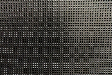 Highresolution image of a dark gray perforated metal sheet.  Uniformly spaced round holes create a textured background ideal for industrial, tech, or abstract design projects.