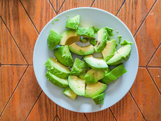 Freshly sliced avocado on a plate.  Vibrant green hues and a natural, rustic feel. Perfect for healthy eating, food blogs, and recipe websites.
