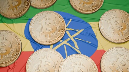 Several bitcoins are laid out on the flag of Ethiopia