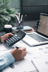 Finance bank tax expense accounting budget money businessman hand use calculator Financial calculate accountant close up calculator with graph chart write office desk Business expense analysis saving
