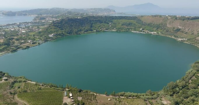 Aerial view of Lake Avernus (Lago d'Averno) located Pozzuoli, near Naples, in Campania, Italy. It is a volcanic crater lake located in Phlegraean Fields (Campi Flegrei). The lake is roughly circular.