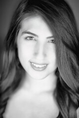 Fototapeta premium Young woman photographed in a stylish black and white portrait smiling to the camera 