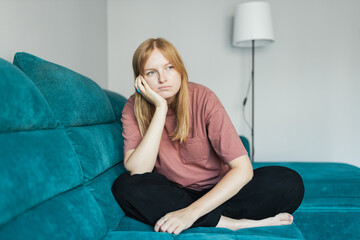Bad day. Frustrating young 30s female siting on the sofa. Cheerful 30s woman sit on couch spending...