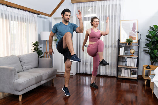 Athletic and sporty fitness couple or exercise buddy running posture at home body workout exercise session for fit physique and healthy sport lifestyle at home. Gaiety home exercise workout training.