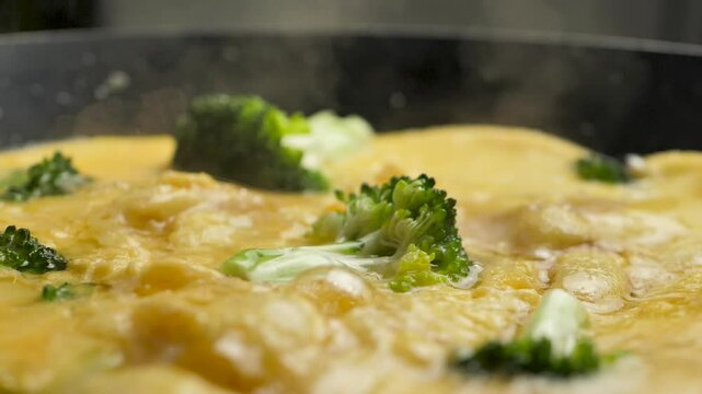 Close-up of hot omelette with broccoli frying in a frying pan. Vegetarian food. Healthy diet and nutrition. Healthy lifestyle. Food with vegetables