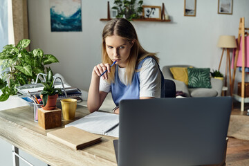 Focused girl reflects on her studies while sitting at a stylish desk in her room, deep in thought.